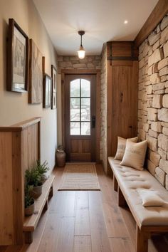 a wooden bench sitting in the middle of a hallway next to a stone wall and door