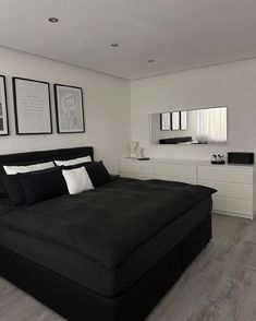 a black and white bedroom with pictures on the wall