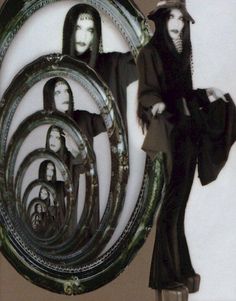 a woman in black is standing next to a mirror with images of women on it