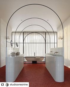 a bathroom with red carpeting and white fixtures on the walls, along with an arched ceiling