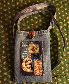 a handbag made out of jeans with an orange and blue patchwork design on the front