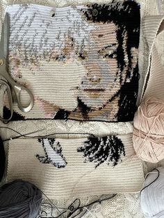 a pair of scissors and some yarn sitting on a table next to a bag with an image of marilyn monroe