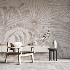 two chairs and a table in front of a wall with a plant on the side