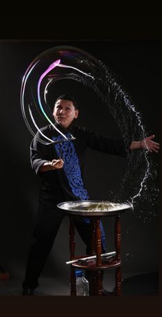 a man is standing in front of a table with water sprinkles on it