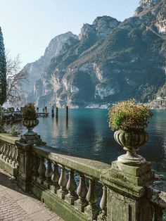 a large body of water sitting next to a lush green forest covered mountain side town