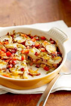 a casserole dish on a table with a fork and napkin next to it