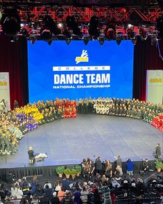 a large group of people standing on top of a stage in front of a crowd