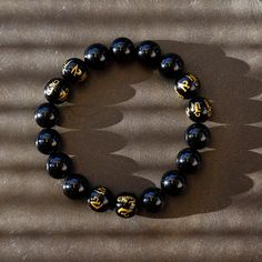 This is a mystical crystal beaded Mala bracelet, with the fusion of black onyx with the power of a Tibetan Buddhist Symbols -- 6 of the onyx beads are engraved the golden symbols! It gives the Peace, the Power, and the Protection to the person who wear it. Size(this brace let comes in 3 sizes, please select carefully):Size(this brace let comes in 3 sizes, please select carefully): -----Small: Bead diameter: 3/8 inch (10 mm) Bracelet circumference: 6 inch (15 cm) -----Medium: Bead diameter: 1/2 i Black Spiritual Beaded Jewelry, Black Onyx 8mm Bead Jewelry, Black Onyx 8mm Beads Jewelry, Black Onyx Jewelry With 8mm Beads, Black Round Spiritual Jewelry, Spiritual Obsidian Jewelry With Black Beads, Spiritual Obsidian Black Beads Jewelry, Symbolic Black Jewelry For Healing, Symbolic Black Jewelry With 108 Beads