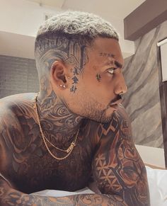 a man with tattoos on his face and chest