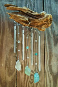 a wind chime hanging from a tree branch with sea glass and crystal beads on it