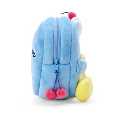 a small blue backpack with pom poms on the front and back straps, sitting next to a yellow toy