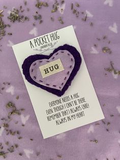 a purple heart shaped brooch sitting on top of a card