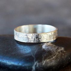 a silver ring sitting on top of a rock