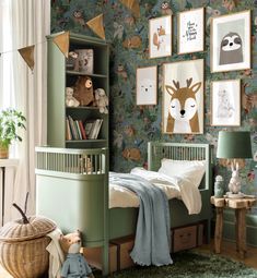 a child's bedroom with green walls and pictures on the wall