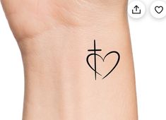 a cross and heart tattoo on the left side of the wrist, with an arrow in the center