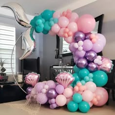 a balloon arch with mermaid balloons and other decorations