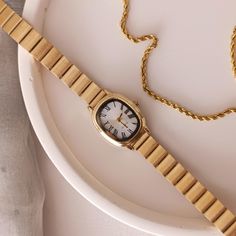 ➡ Product Features: 📏 Case Diameter 20*25 mm ⌚ Suitable for daily use 💪  Steel case ⚙️ Quartz mechanism. 💎 Mineral glass is used. ✈Free shipping. -Timeless elegance meets modern charm in our exquisite Gold Colour Minimal Wrist Watch for Women. This stunning timepiece is a true embodiment of sophistication, featuring a lustrous white dial adorned with delicate Roman numerals, reminiscent of bygone eras. Crafted to perfection, the adjustable band ensures a comfortable and customized fit, allowi Gold Minimalist Watch Accessories For Everyday, Everyday Gold Watch With Metal Dial, Gold Minimalist Watches, Timeless Adjustable Watch Accessories For Gift, Everyday Watch Accessories With Bracelet Strap And Round Dial, Timeless Adjustable Watch Accessories As Gift, Gold Stainless Steel Watch Accessories For Everyday, Minimalist Gold Watch With Adjustable Fit, Minimalist Adjustable Gold Watches