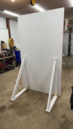 a large white piece of furniture in a garage with tools on the floor and around it