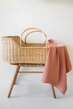 a baby's crib with a pink blanket on it and a wooden stool