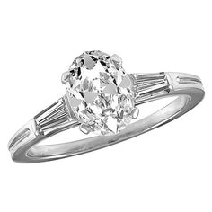 Sparkling oval brilliant cut engagement ring. Made and signed by TIFFANY & CO. The center stone is 1.20 cts. H-I color, VS1, very good symmetry, no fluorescence. One tapered diamond baguette on each side. Size 6 1/2 and can be custom-sized. Set in platinum. A fiery brilliant ring. Alice Kwartler has sold the finest antique gold and diamond jewelry and silver for over 40 years. Oval Solitaire Diamond Ring In Platinum, Gia Certified Oval White Wedding Rings, Oval Brilliant Cut Platinum Wedding Ring, Classic Oval Diamond Ring With Vvs Clarity, Classic Oval Brilliant Cut Diamond Ring, Classic Oval Diamond Ring With Center Stone, Classic Oval Center Stone Wedding Ring, Brilliant Cut Engagement Ring, Brilliant Cut Engagement Rings