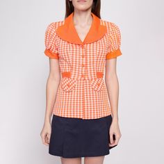 Super cute vintage 70s orange and white gingham top with buttons up the front, a rounded notched collar, short puff sleeves, and a tie at the back of the waist to cinch. A few condition notes, see details below. Measurements and Condition:    Fits like: Women's small Fabric: Feels like double-knit polyester, fabric has a bit of stretch Brand: Unknown, the tag is faded Condition: Good, with fading on the left sleeve/shoulder and lower left side (see photos), a 1/3" seam gap on the underside of th 70s Orange, Orange Gingham, Gingham Tops, Collared Shirt, Puff Sleeve Top, Double Knitting, Womens Clothing Tops, Gingham, Puff Sleeve