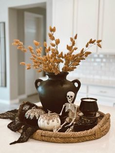 a black vase filled with flowers on top of a table next to candles and other items