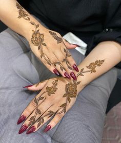 a woman's hands with hennap and flowers on them