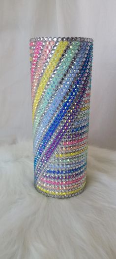 a multicolored glass vase sitting on top of a white furnishing covered floor