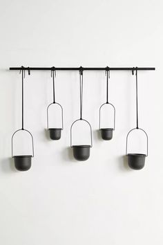 five hanging lights on a white wall with no one in the room to see them