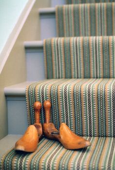 two wooden birds sitting on top of a carpeted stair case