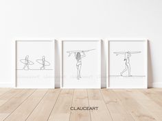 three framed art prints depicting surfers with surfboards on their heads, one in black and white