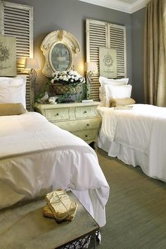 an image of two beds in a room with white linens and gold accessories on them