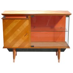 a wooden cabinet with glass doors and two drawers on one side, against a white background