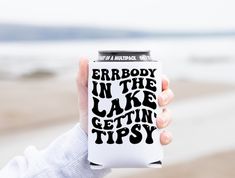 someone holding up a can of beer with the words everybody in the lake gettin'tipsy on it