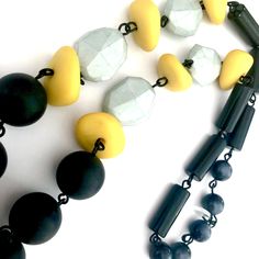 Matte black and charcoal moonglow beads mixed with golden yellow and mint green in a hand-linked Bohemian rope style necklace, loaded with rare vintage beads. Beads are linked by hand with black wire chain. The Carmen necklace measures 26" +/- in length & slips right over your head in a great versatile style. Made with lucite from 1960's deadstock, from a warehouse that closed in the early 1980's. *Because beads are vintage, your necklace may vary slightly from what is pictured, but not in a Black Vintage Jewelry With Multicolored Beads, Unique Hand-strung Yellow Necklace, Black Vintage Large Beads, Unique Hand-strung Yellow Beads, Vintage Yellow Polished Beads, Vintage Beads, Moon Glow, Vintage Lucite, Style Necklace