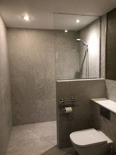 a bathroom with a toilet, sink and shower in it's corner stall area