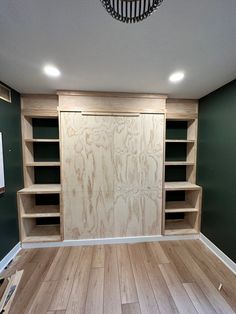 an empty room with wood floors and built - in shelving units on the wall