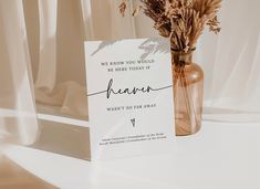 there is a card that has been placed next to a vase with some flowers in it