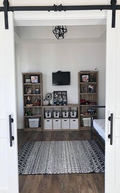 an open door leading to a bedroom with white walls and wooden floors, along with several storage units