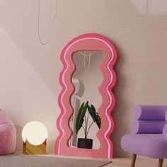 a pink mirror sitting on top of a floor next to a purple chair