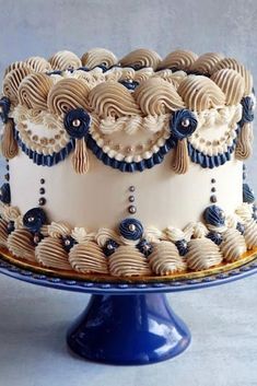 a white and blue decorated cake sitting on top of a table