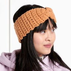 a woman wearing a headband made out of crocheted yarn and looking off to the side