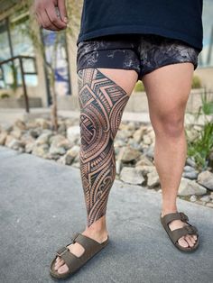 a man with tattoos on his leg and foot