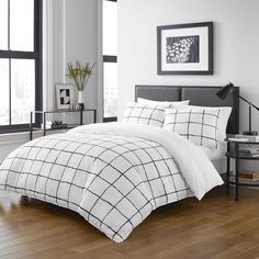 a bed with white and black comforters in a room