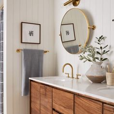 a bathroom with a sink, mirror and towels hanging on the wall next to it