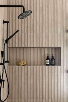 a bathroom with a shower head and shelves on the wall