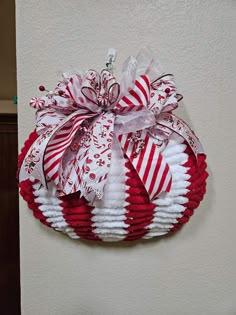 a red and white christmas wreath hanging on the side of a wall with candy canes