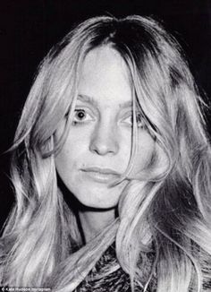 a black and white photo of a woman with long blonde hair wearing a fur coat