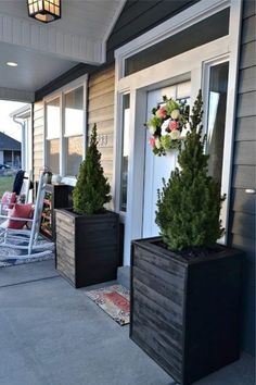 two black planters on the front porch