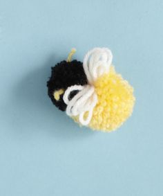 a small black and yellow object on a blue surface with white thread in the middle